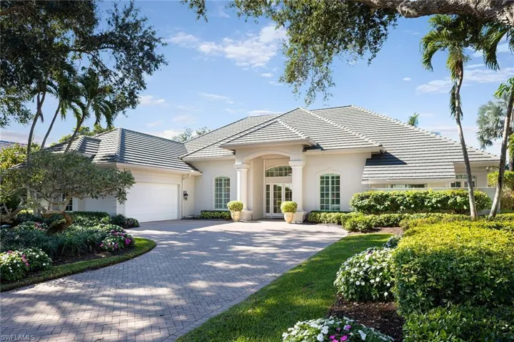 View of front of house featuring decorative driveway, a garage, a tile roof, and stucco siding