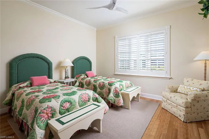 Bedroom featuring wood-type flooring, crown molding, and a ceiling fan