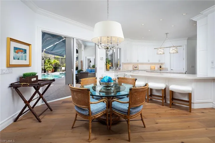 Dining room featuring ornamental molding, light wood finished floors, a chandelier, a sunroom, and recessed lighting