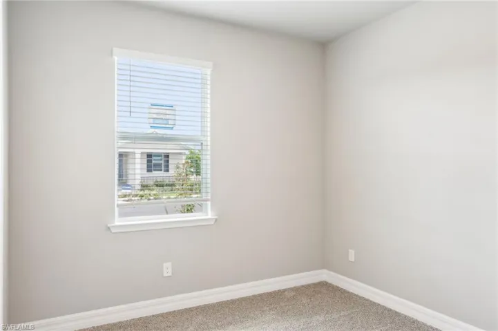 Empty room featuring carpet flooring and baseboards
