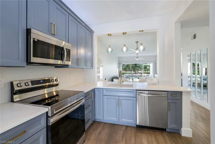 Kitchen featuring visible vents, dark wood-style floors, a sink, and appliances with stainless steel finishes