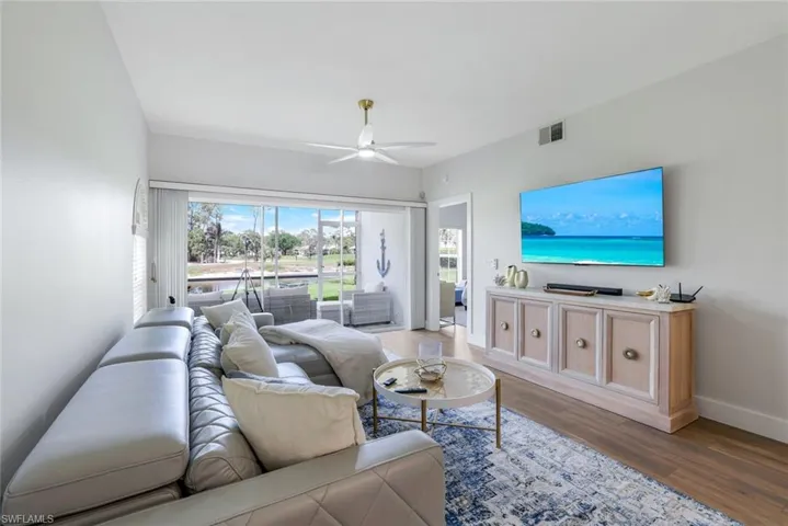 Living room with a ceiling fan, wood finished floors, baseboards, and visible vents