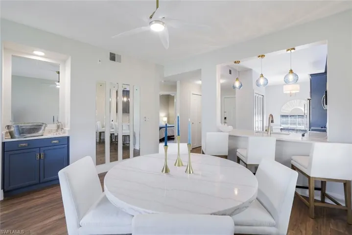 Dining room with visible vents, ceiling fan, and dark wood-style flooring