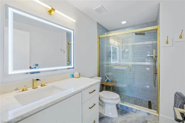 Full bath with a stall shower, toilet, and vanity