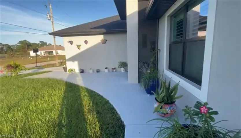 View of property exterior featuring a patio and a lawn
