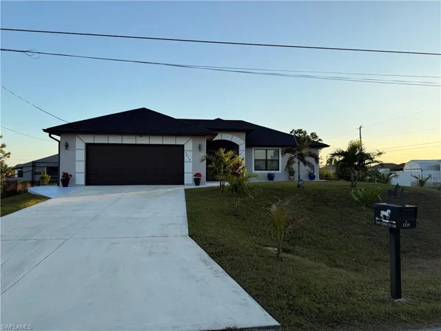 View of front of property featuring a yard and a garage