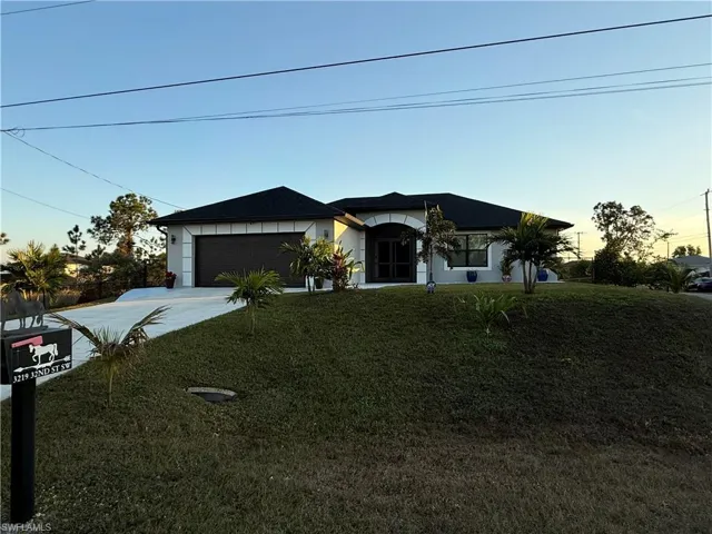 View of front of home with a yard and a garage