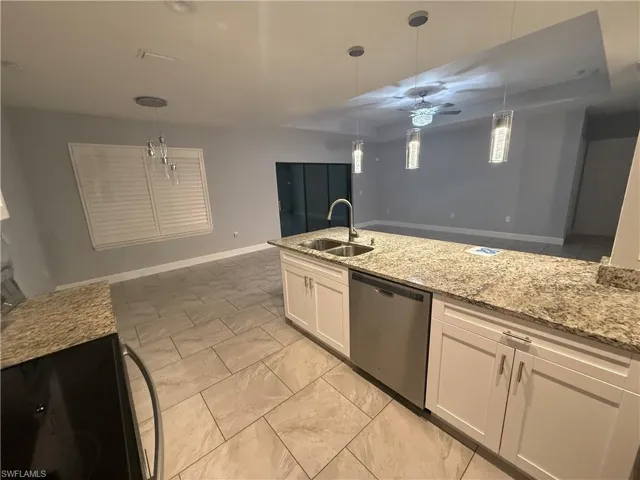 Kitchen featuring pendant lighting, dishwasher, white cabinets, ceiling fan, and light stone countertops