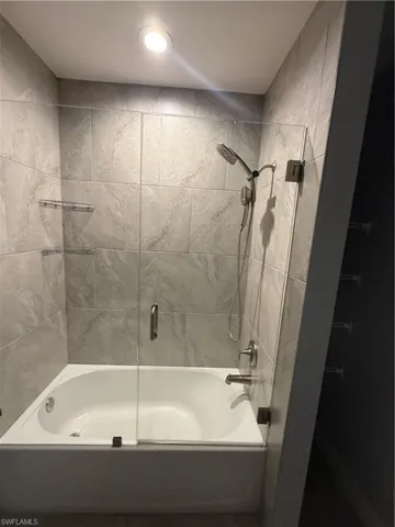 Bathroom with shower / bath combination with glass door