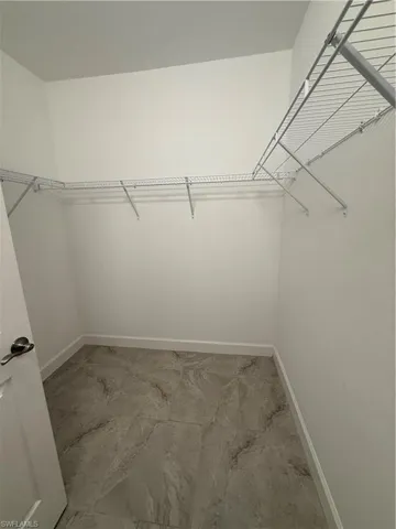 Spacious closet featuring marble finish floor