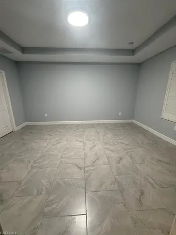 Spare room featuring marble finish floor, visible vents, and baseboards