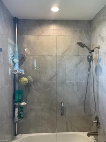Bathroom featuring bath / shower combo with glass door