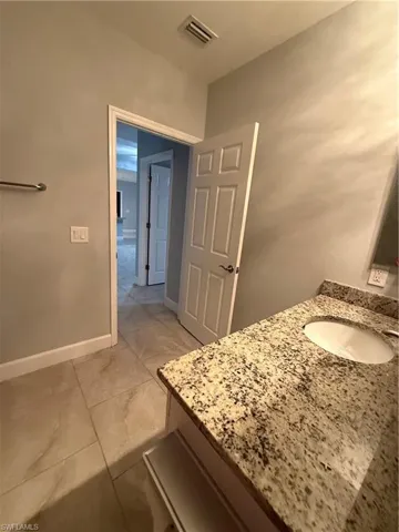 Bathroom featuring visible vents, vanity, and baseboards