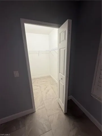 Walk in closet with marble finish floor