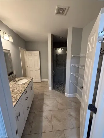 Bathroom featuring vanity and a shower with shower door