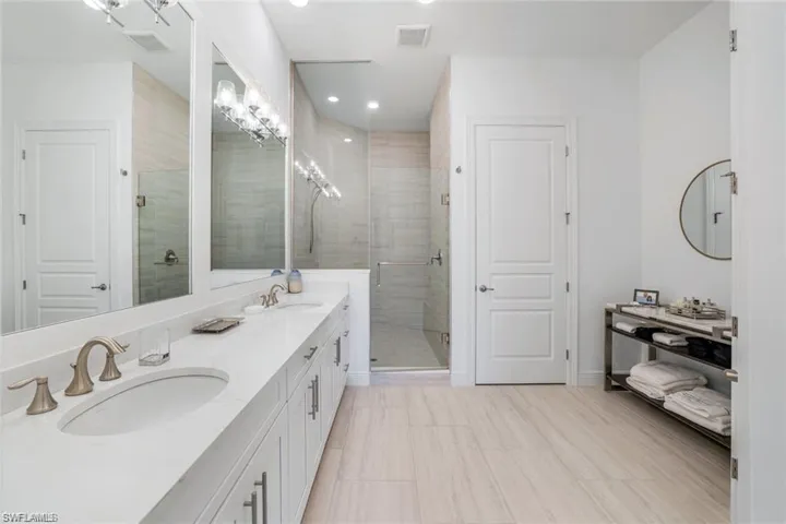 Primary bath featuring double vanity, shower