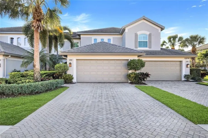 View of front of house with stucco siding, a garage, decorative driveway, and a tiled roof