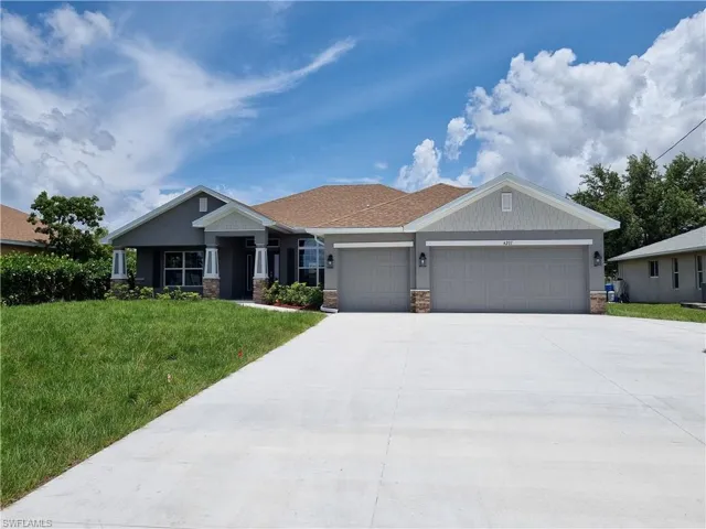 Craftsman inspired home featuring a garage, a front lawn, and driveway