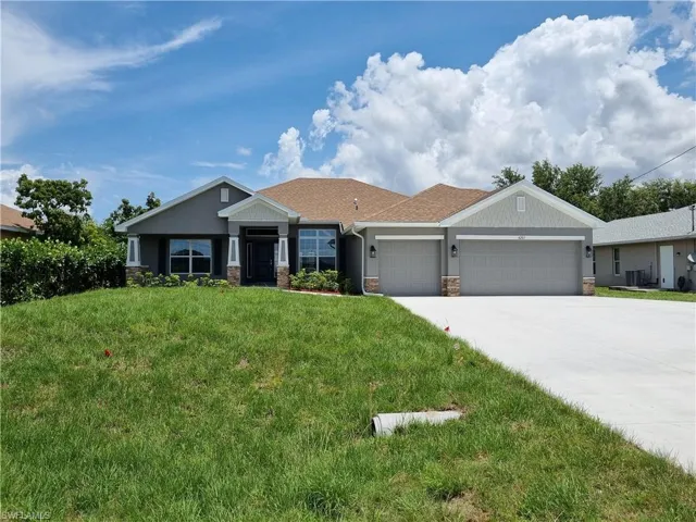 Craftsman inspired home with an attached garage, a front lawn, concrete driveway, stone siding, and central AC unit
