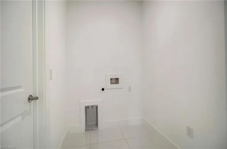 Clothes washing area with electric dryer hookup, tile flooring, and hookup for a washing machine