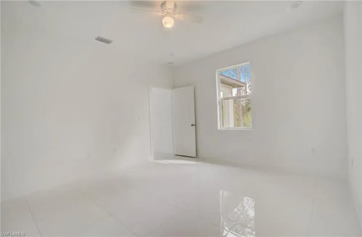 Tiled empty room featuring ceiling fan