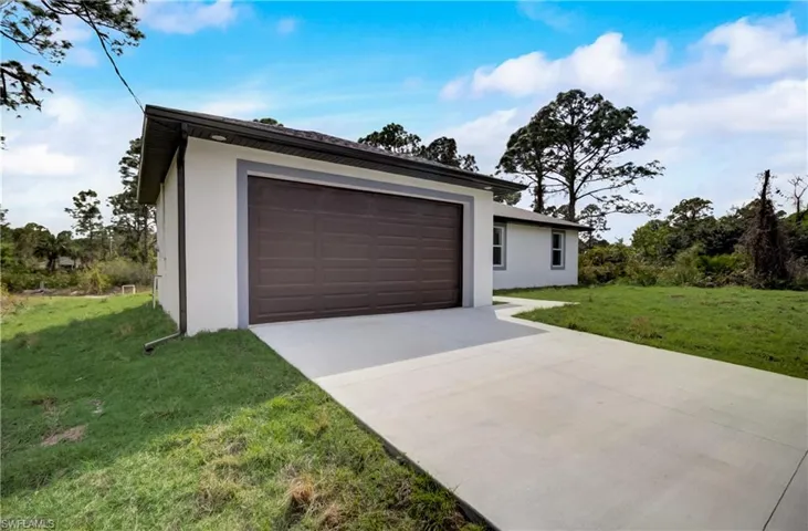 Garage featuring a lawn
