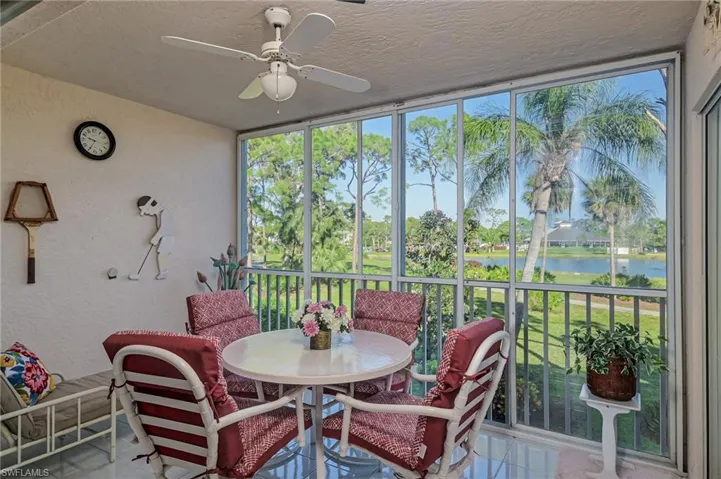 Sunroom / solarium with ceiling fan and a water view