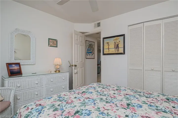 Carpeted bedroom with ceiling fan and a closet