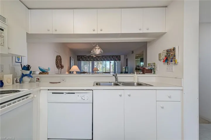 Kitchen with sink, white cabinetry, and white appliances