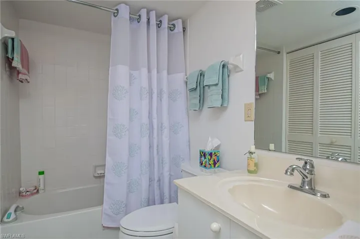Full bathroom with toilet, shower / bath combo with shower curtain, and vanity
