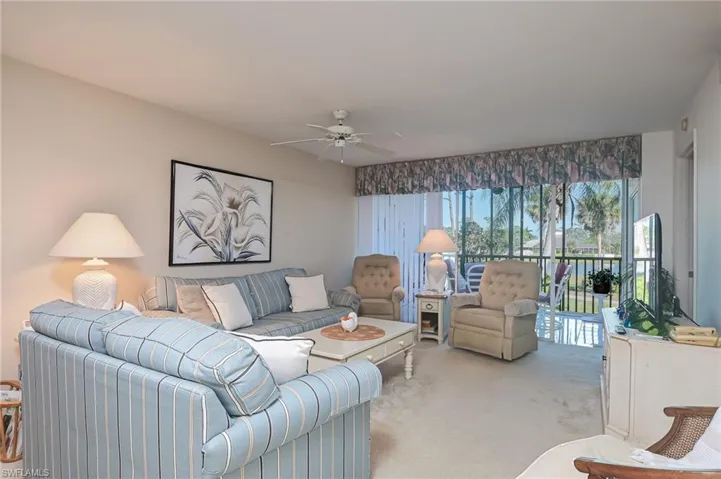 Living room with light colored carpet and ceiling fan