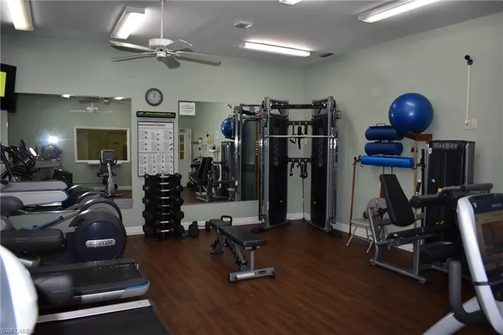 Gym with ceiling fan and wood-type flooring