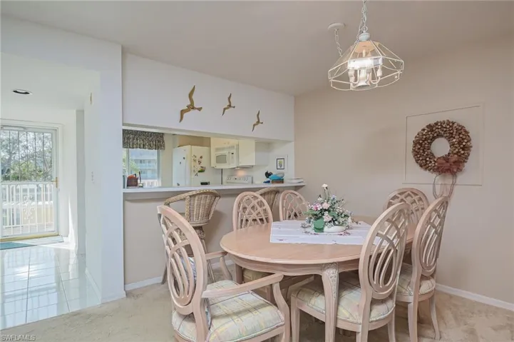 Dining space featuring light carpet and a chandelier