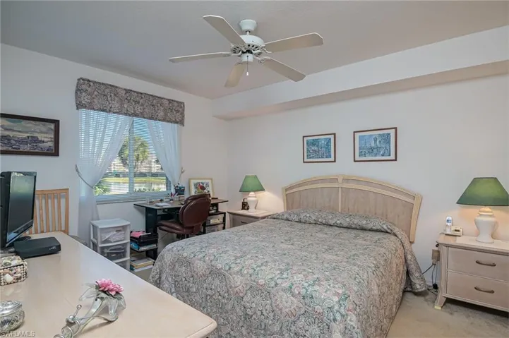 Carpeted bedroom featuring ceiling fan