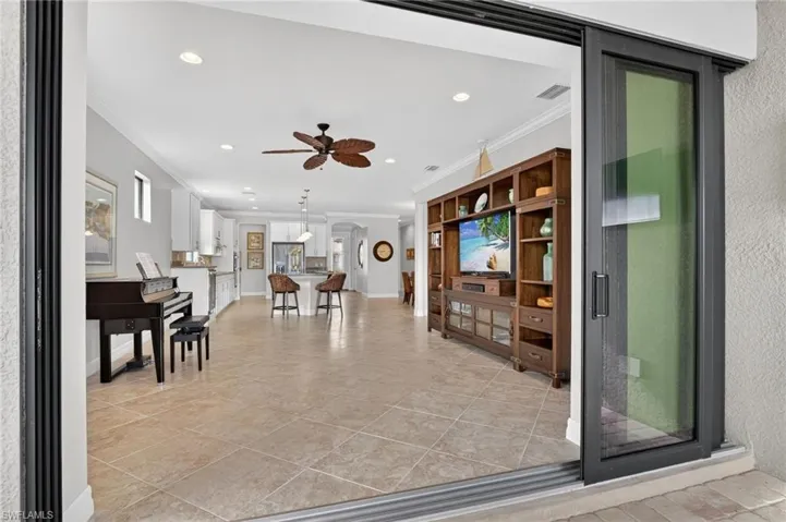 Living room with crown molding, ceiling fan, recessed lighting, and light tile patterned flooring
