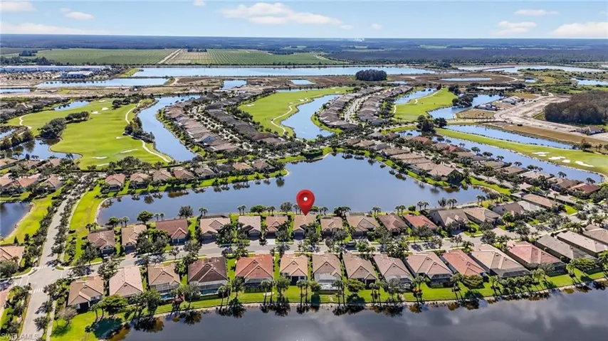 Aerial view of residential area with a nearby body of water and a golf club
