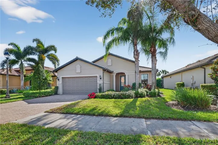 Mediterranean / spanish-style house with stucco siding, a front yard, a garage, and decorative driveway