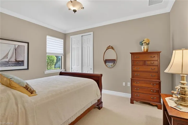 Bedroom featuring a closet, light carpet, and ornamental molding
