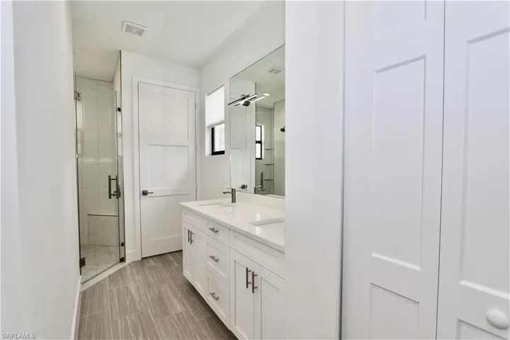 Main Bathroom featuring  an enclosed shower, double sink vanity and private water closet