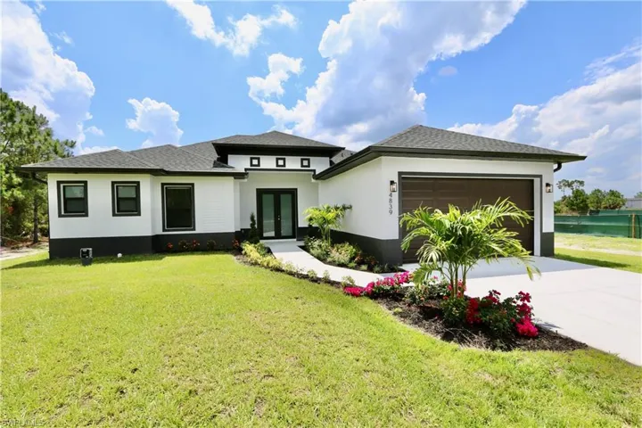 Prairie-style home featuring a garage and a front yard