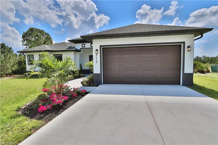 View of front of home with a front lawn and a garage