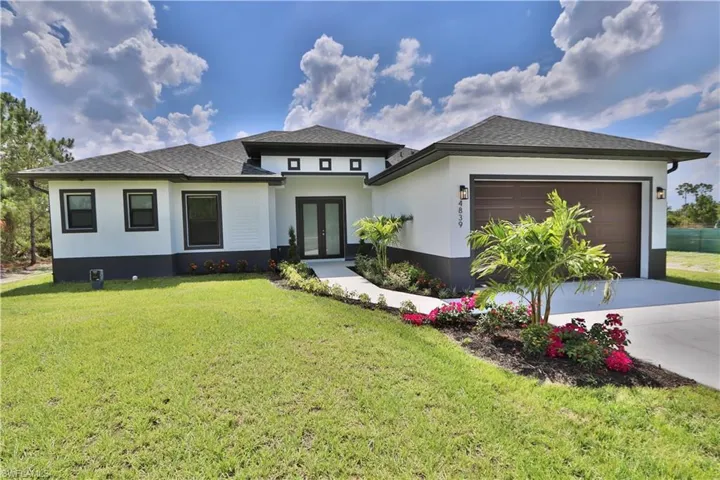 Prairie-style home featuring a garage and a front yard
