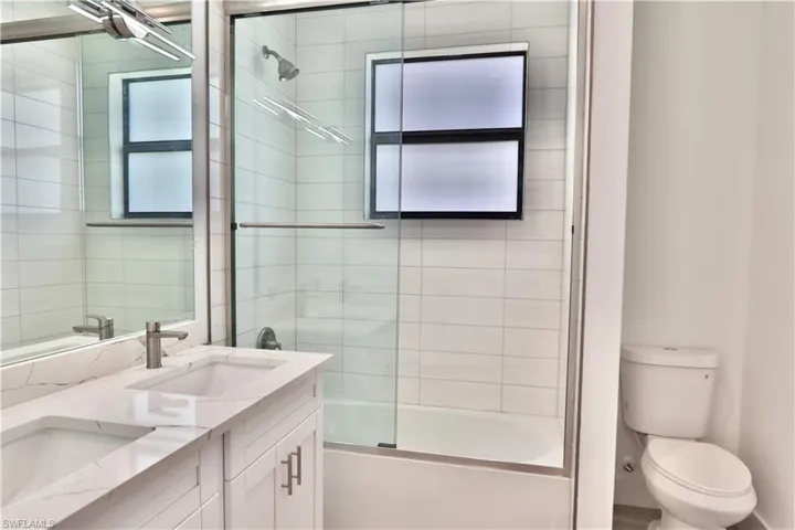 2nd Full bathroom featuring combined bath / shower with glass door, double vanity