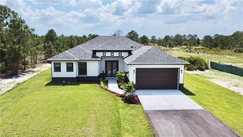 View of front facade featuring a front yard and a garage