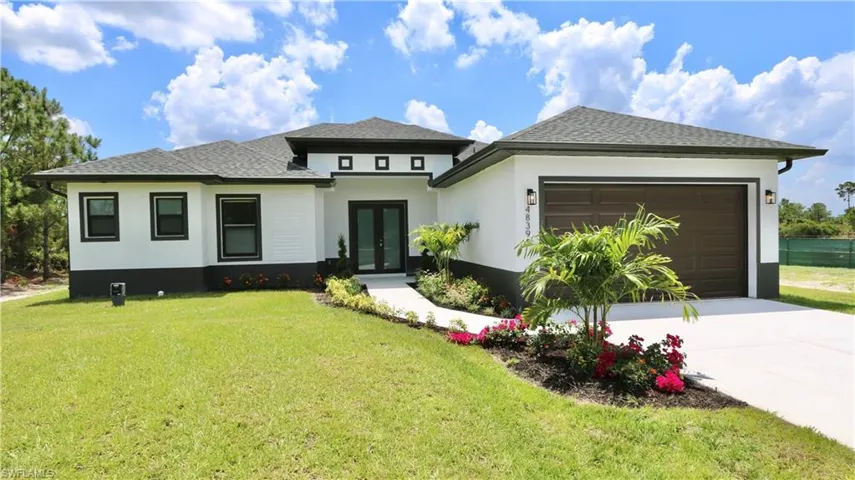 Prairie-style house featuring a garage and a front lawn