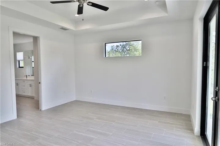 Main bedroom with ceiling fan and a tray ceiling