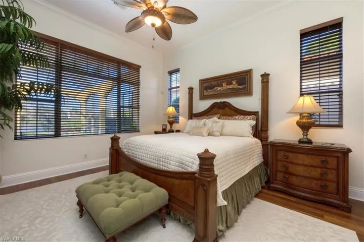 Bedroom with wood finished floors, crown molding, multiple windows, and a ceiling fan