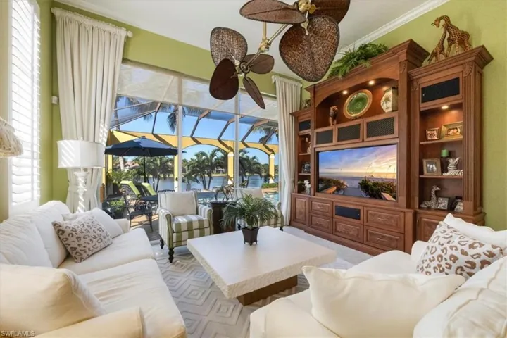 Living area with a sunroom, crown molding, and ceiling fan