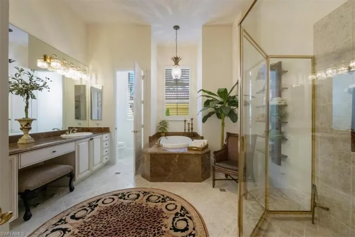 Bathroom with vanity, a garden tub, a shower stall, and light tile patterned flooring