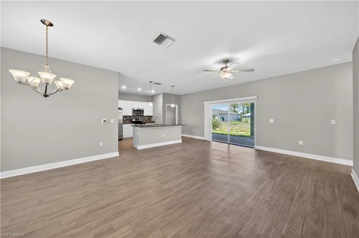 Expansive open concept living area featuring wood-look flooring and light gray walls